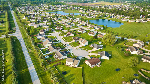 Large neighborhood with two ponds distant farmland aerial