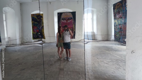 a woman and a man take a selfie in the mirror of the large hall of an ancient palace. old castle Podgortsy, Lviv region, Ukraine.