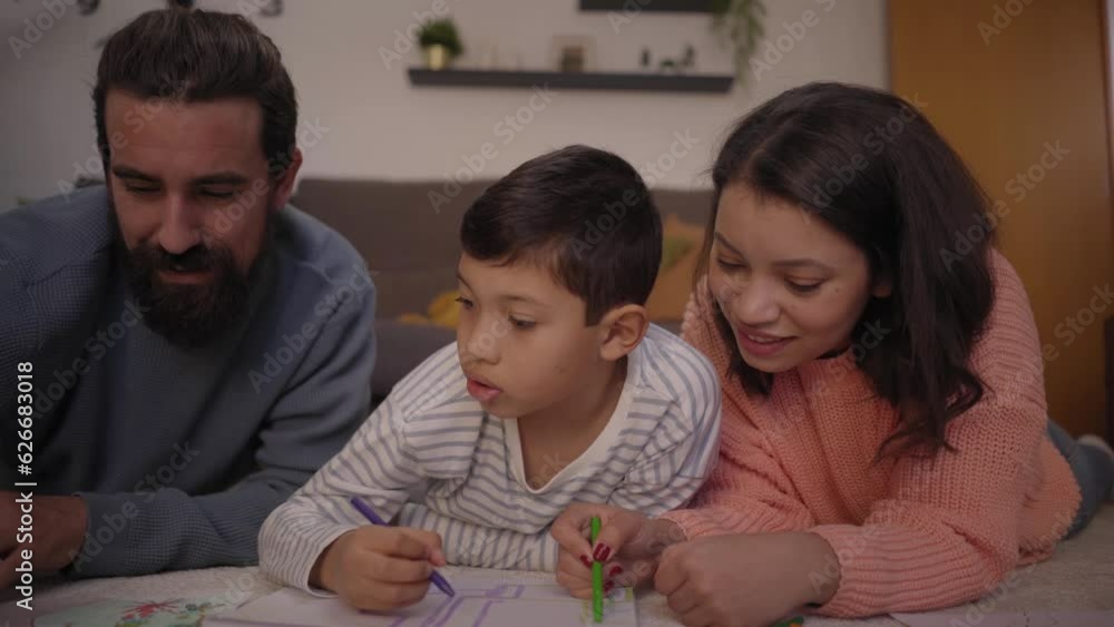 Close up young multiracial parents helping only child with homework at home. United family doing creative activities lying in living room. Concept of home schooling and childhood development. Close up young multiracial parents helping only child with homework at home. United family doing creative activities lying in living room. Concept of home schooling and childhood development.