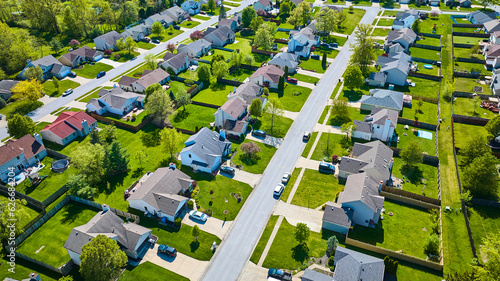 Foto Pristine rows of houses in white collar suburban neighborhood aerial with landsc
