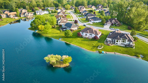 Pond with small island in rich mini mansion housing addition million-dollar homes
