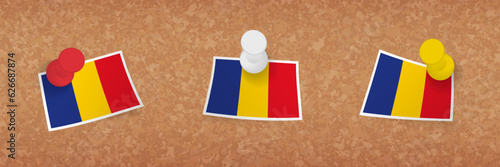 Romania flag pinned in cork board, three versions of Romania flag.