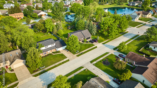 Neighborhood with fountain in pond and fresh cut green summer grass aerial