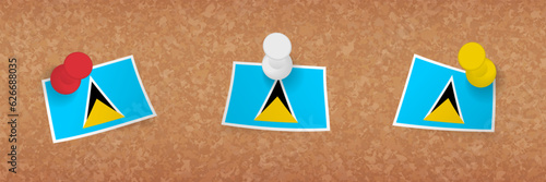 Saint Lucia flag pinned in cork board, three versions of Saint Lucia flag.