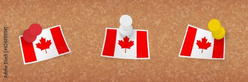 Canada flag pinned in cork board, three versions of Canada flag.