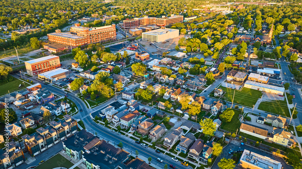 Fototapeta premium Golden glow sunrise houses, businesses, factory cityscape landscape neighborhood aerial