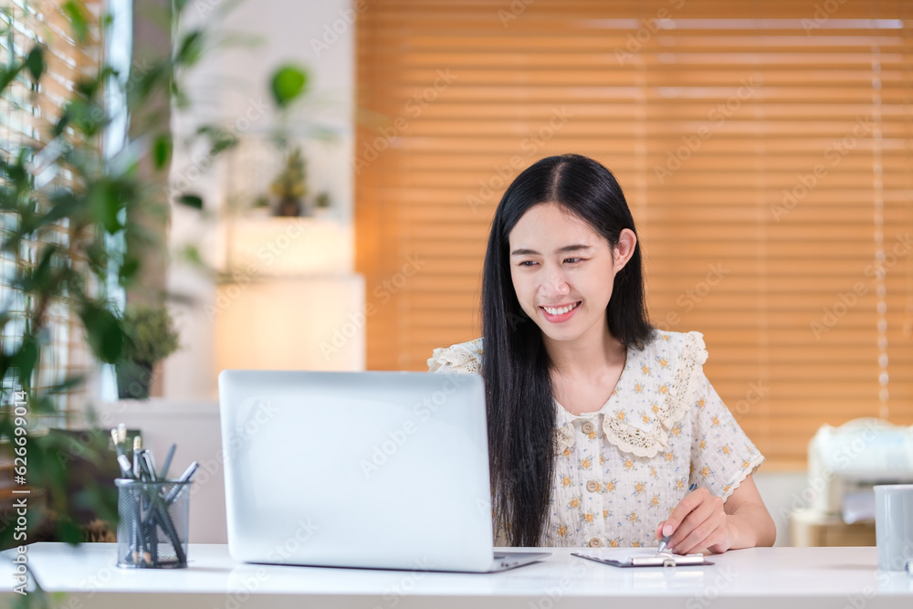 Image of beautiful Asian female entrepreneur using laptop planning work projects at workplace. Image of beautiful Asian female entrepreneur using laptop planning work projects at workplace.