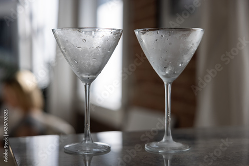 Chilled martini glasses on reflective tile surface