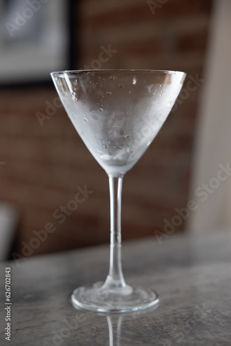 Chilled martini glass on reflective tile surface