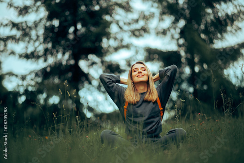Fotografie Happy Millennial Woman Relaxing in the Grass Enjoying Nature