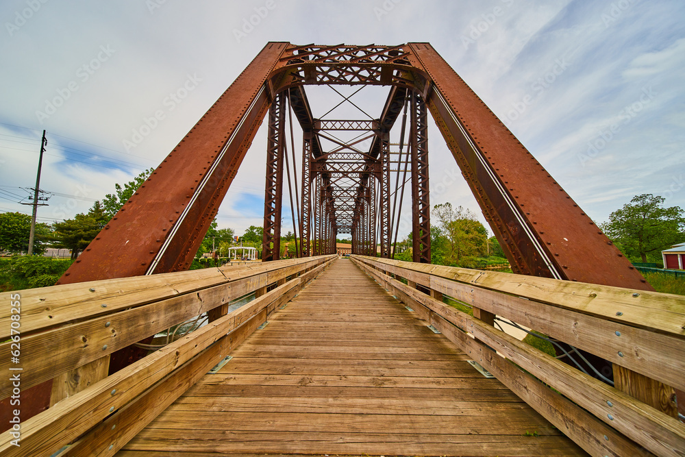 Wooden walking bridge cutting through rusty iron train bridge in Mount Vernon Ohio