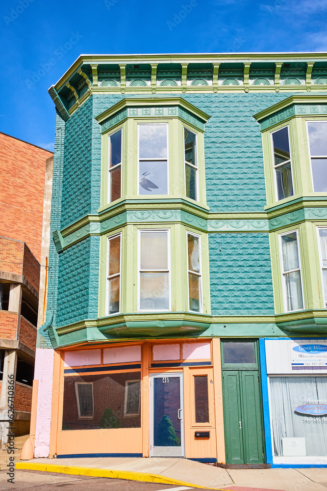 Partial view of brick building with teal paint and bay windows in Public Square in Mount Vernon
