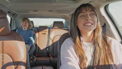 Close up portrait of family inside car on trip. Happy family of people in car young beautiful mom with teenage son. Concept of safety journey, vacation, holidays. Childhood and parenthood.