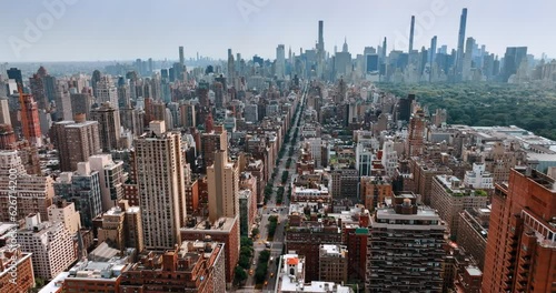 Stunning scenery of New York at daytime. Drone footage above the road leading through the beautiful quarters to downtown with skyscrapers.