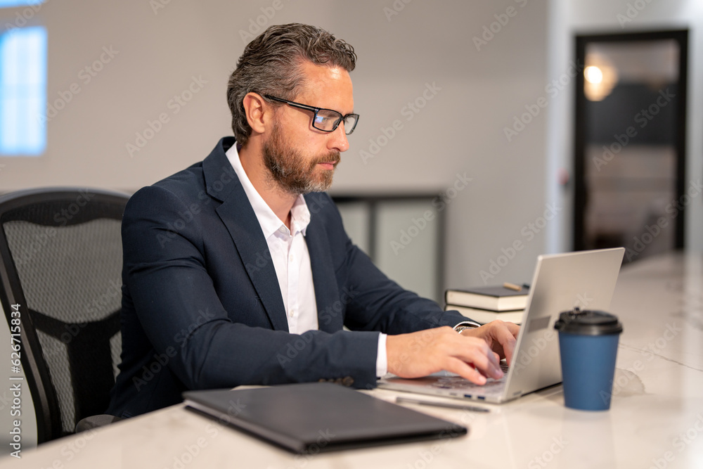 Business worker with laptop at office. Employee remote working in modern office. Business man on online meeting. Hispanic business man working online. Mature business man using laptop at workplace. Business worker with laptop at office. Employee remote working in modern office. Business man on online meeting. Hispanic business man working online. Mature business man using laptop at workplace.