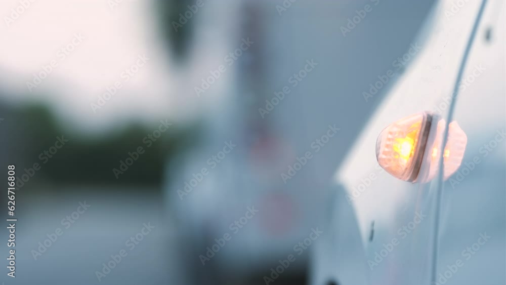 Close-Up Shot of White Car With Flashing Side Signal, White Car Is Stop With Warning Signal. Detail Shot of Blinking Warning Light Close-Up Shot of White Car With Flashing Side Signal, White Car Is Stop With Warning Signal. Detail Shot of Blinking Warning Light