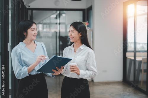 Two young businesspeople using business data while standing in a boardroom. Two business colleagues having a discussion during a meeting.