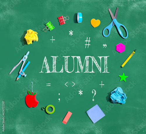 Alumni theme with school supplies on a chalkboard - flat lay