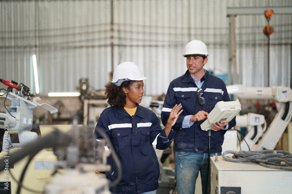 Multiracial industrial engineers working at automated AI robotic production factory, New industrial technology concept. Multiracial industrial engineers working at automated AI robotic production factory, New industrial technology concept.