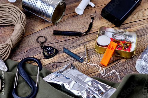 Wilderness survival kit on wooden table.