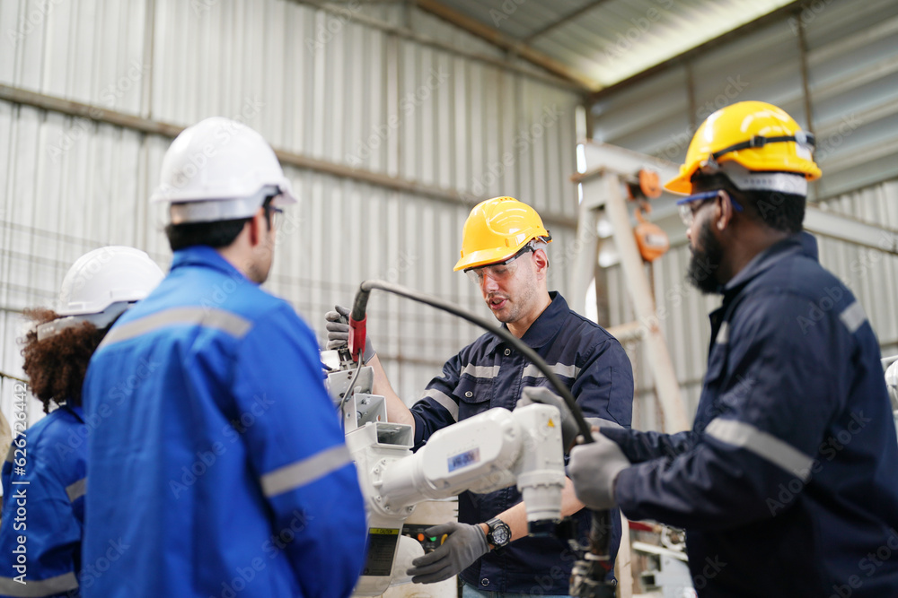 Multiracial industrial engineers working at automated AI robotic production factory, New industrial technology concept. Multiracial industrial engineers working at automated AI robotic production factory, New industrial technology concept.