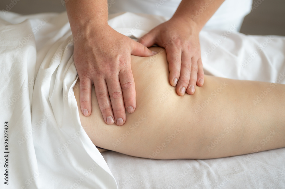 Anti-cellulite massageon the hips and buttocks. The masseur massages the buttocks, thigh and legs. Relaxing treatment Anti-cellulite massageon the hips and buttocks. The masseur massages the buttocks, thigh and legs. Relaxing treatment
