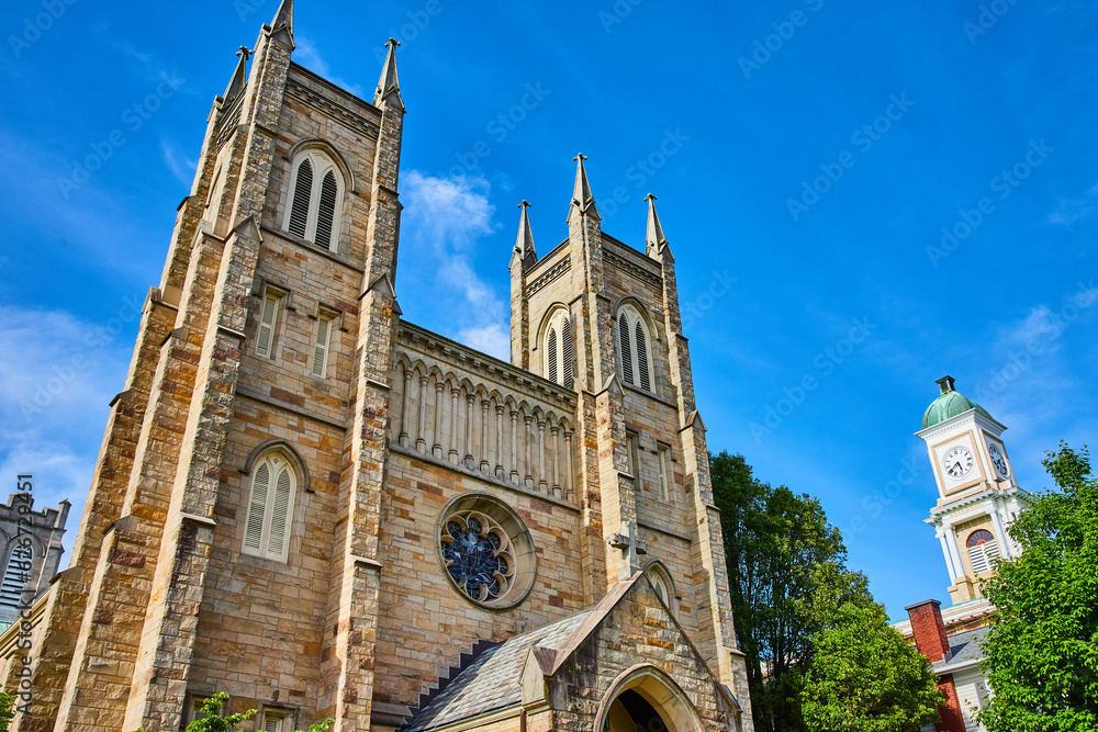 Fototapeta premium Top view of St. Pauls Episcopal Church with blue sky and tops of green trees in Ohio