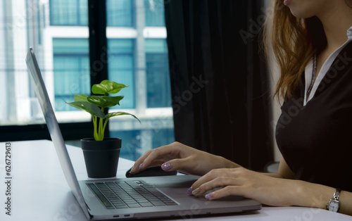 Close up woman using laptop computer on white desk. Tachnology and business concept photo