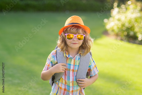 Fashion summer kids portrait. Outdoor closeup portrait of funny kids face. Summer kid outdoor portrait. Close up face of cute child. Kid having fun outdoor on summer day.