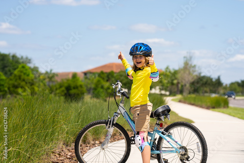 Child on bicycle. Boy in a helmet riding bike. Little cute caucasian boy in safety helmet riding bike in city park. Child first bike. Kid outdoors summer activities. Kid on bicycle. Boy ride a bike.