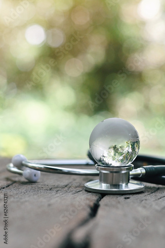 close up glass globe and stethoscope on wood table, life insurance business technology, world health day, medical and healthcare, global pandemic crisis risk and problem