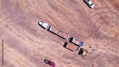 A grain cart offloads wheat onto a trailer for transport to a grain elevator during the Palouse wheat harvest photo