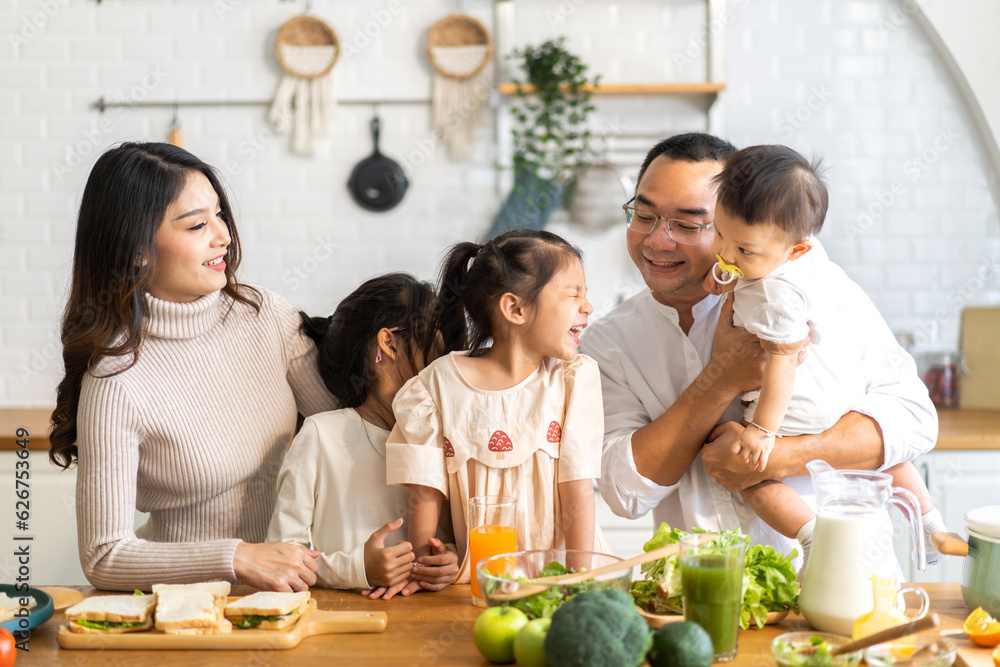 Portrait of enjoy happy love asian family father and mother with little asian girl daughter child having fun help cooking food healthy eat with fresh vegetable salad and sandwich ingredient in kitchen