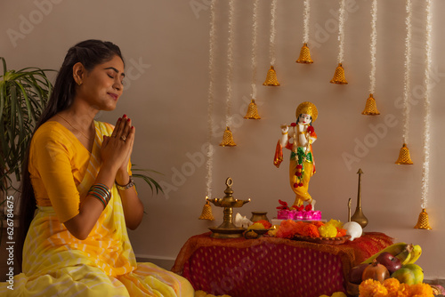 Woman praying to Lord Krishna on the occasion of Janmashtami photo