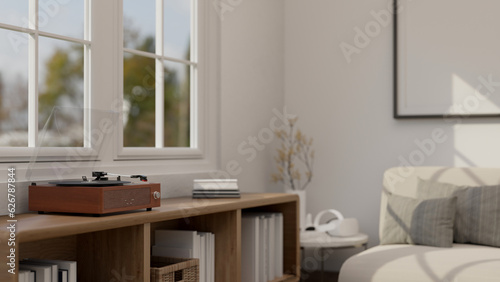 A vintage vinyl record player on a wooden shelf in a cozy Scandinavian living room. © bongkarn