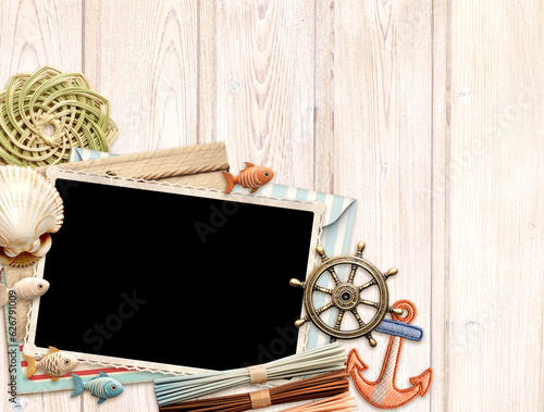 Vintage travel background with retro photo and envelope, postcard, small wooden fish and shell on old wood plank. Horizontal vacation backdrop. Copy space for text