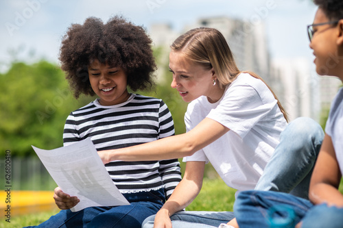 Blonde girl helping kids with home work