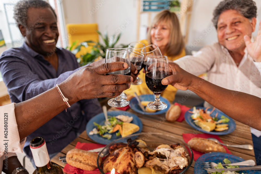 Happy senior friends toasting wineglasses at dinner party Happy senior friends toasting wineglasses at dinner party