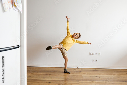 Happy boy doing mischief and having fun in front of white wall photo