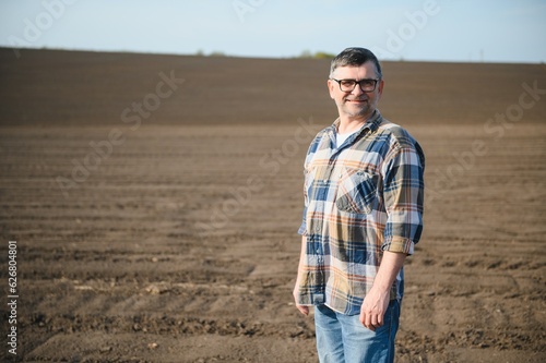Portrait of senior farmer with glasses in field © Serhii