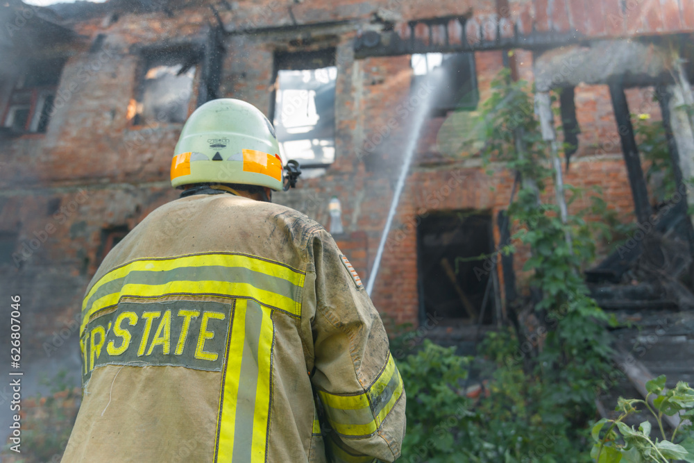 Ukrainian rescuers put out a fire in the house. Firefighters put out the fire from the fire hose. Fire and industrial safety concept Ukrainian rescuers put out a fire in the house. Firefighters put out the fire from the fire hose. Fire and industrial safety concept
