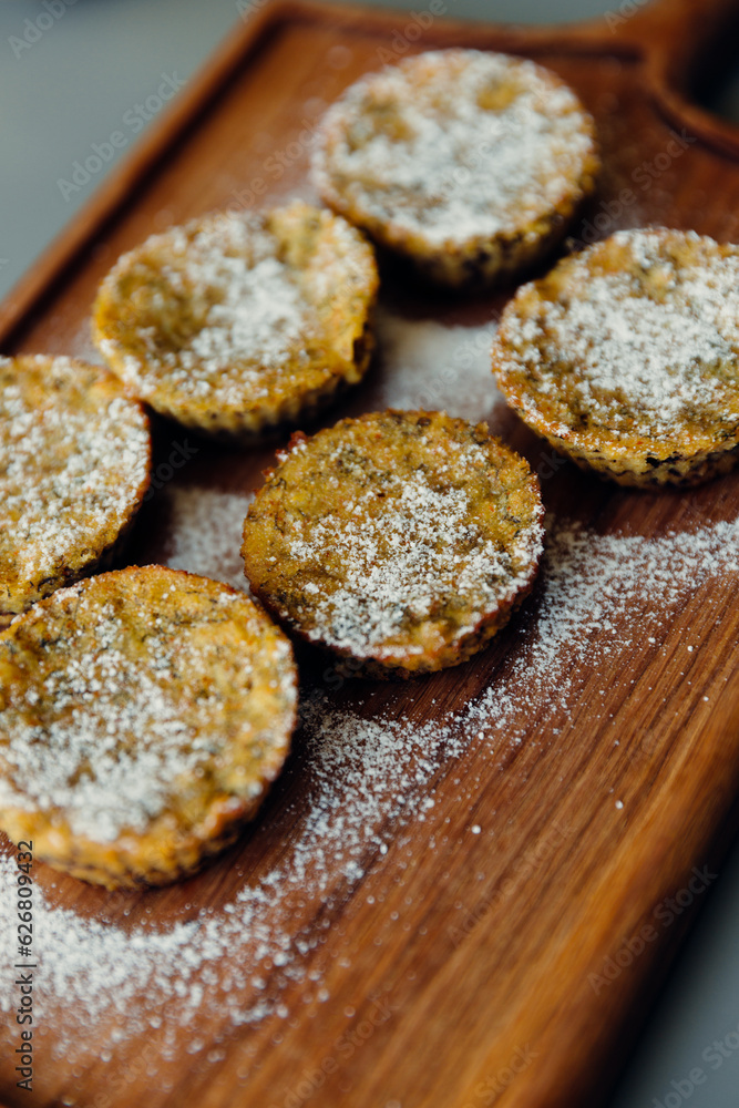 Cupcakes on a wooden board sprinkled with powdered sugar. Gluten and Sugar Free Recipes. Close up