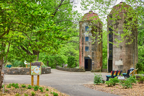 Sensory Garden sign leading to two old silos with pride benches along trail in summer photo
