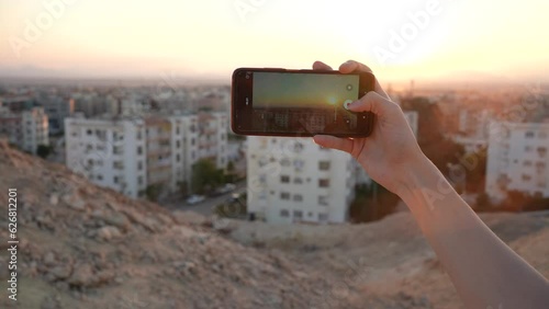 taking videos of desert arab city with a phone in hands in the sunset