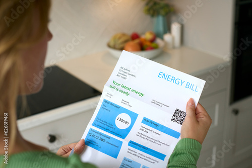 Close Up Of Woman Opening UK Energy Bill During Cost Of Living Crisis photo
