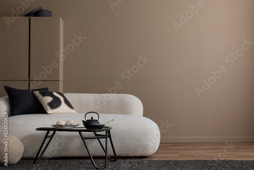 Minimalist composition of warm living room interior with copy space, white boucle sofa, gray plaid, beige pillow, wooden coffee table, brown shelf, and personal accessories. Home decor. Template.