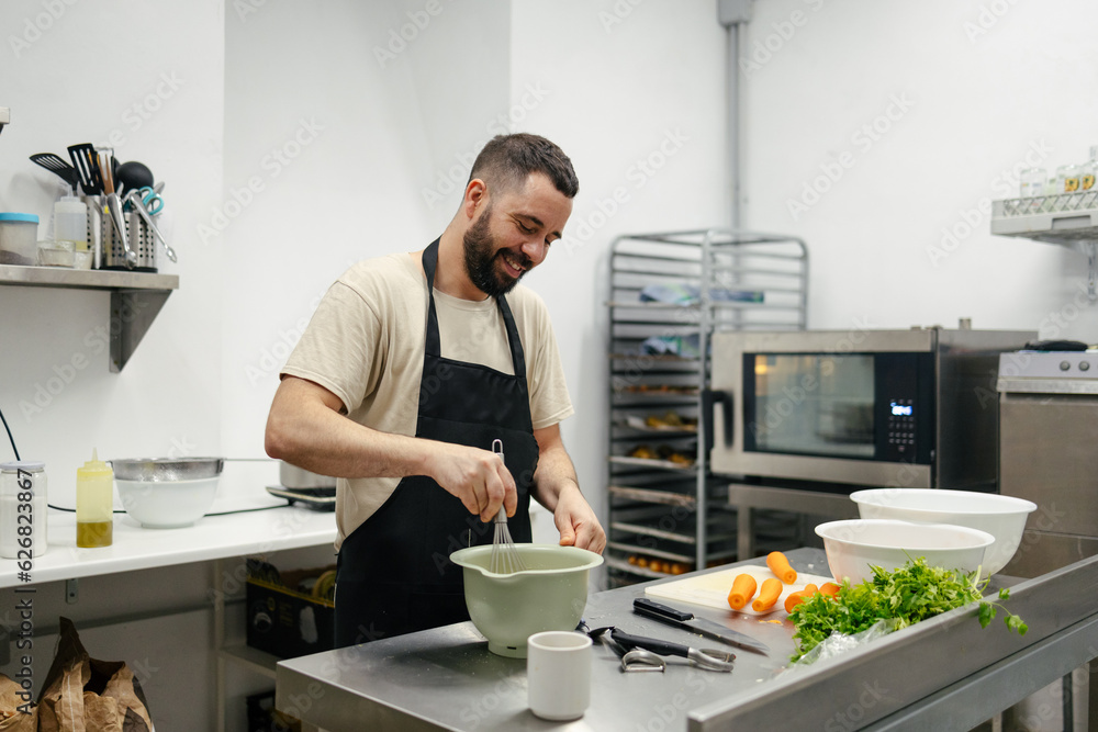 Young chef stirring with cooking rod Young chef stirring with cooking rod