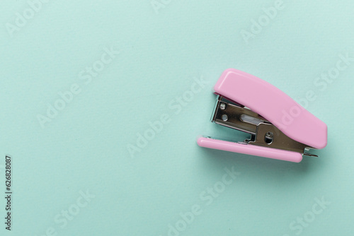 Pink stapler on color backgroung, top view