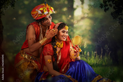 Young man and woman dressed up as Radha and Krishna and romancing on the occasion of Janmashtami photo