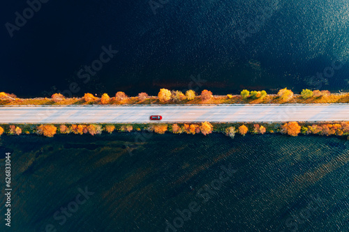 Valokuvatapetti Aerial view of fall road and blue water lake sea ocean